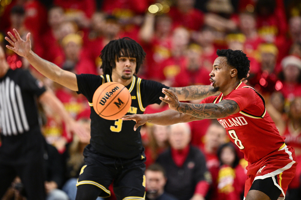 Maryland guard David Coit (8) passes the ball against Michigan guard Elliot Cadeau (3) during the first half of an NCAA college basketball game, Saturday, Dec. 13, 2025, in College Park, Md. (AP Photo/Nick Wass)