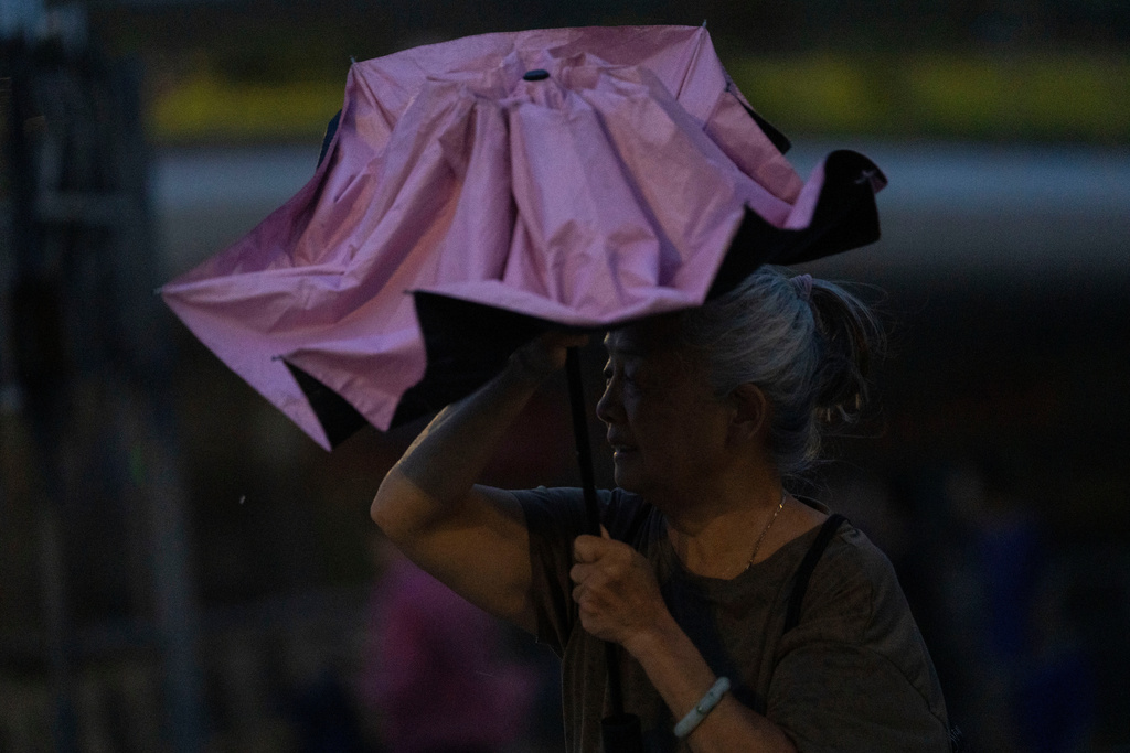 An elderly woman shelters from the rain in the aftermath of Super Typhoon Ragasa in Shenzhen in southern China's Guangdong province on Wednesday, Sept. 24, 2025. (AP Photo/Ng Han Guan)
