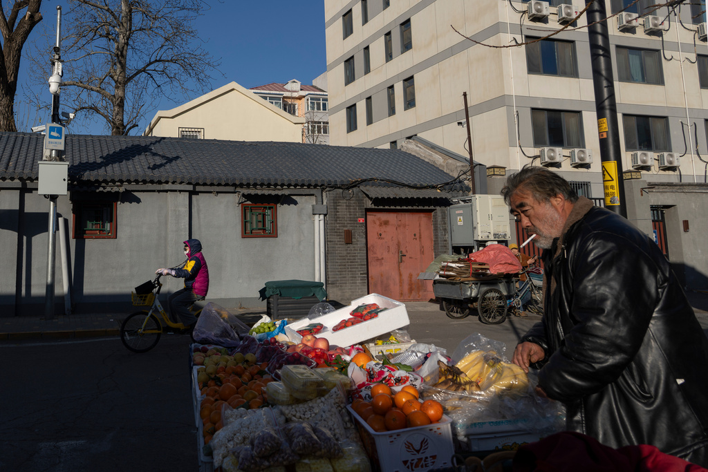 A street vendor sells fruits from a cart man in Beijing, Wednesday, Dec. 24, 2025. (AP Photo/Ng Han Guan)