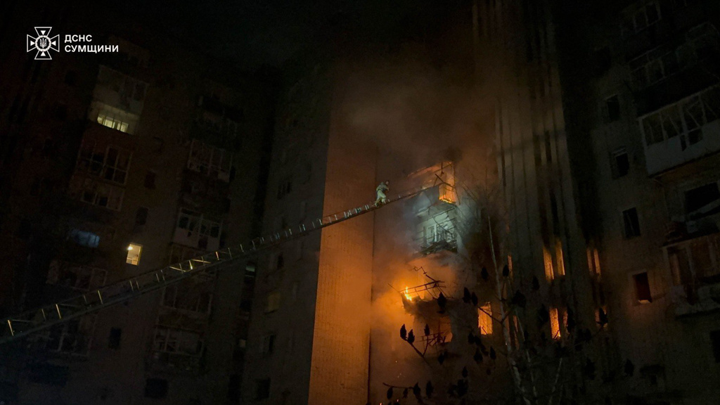 In this photo provided by the Ukrainian Emergency Services on Monday, Dec. 8, 2025, a rescue worker puts out a fire of a residential building damaged by a Russian strike in Sumy region, Ukraine. (Ukrainian Emergency Service via AP)
