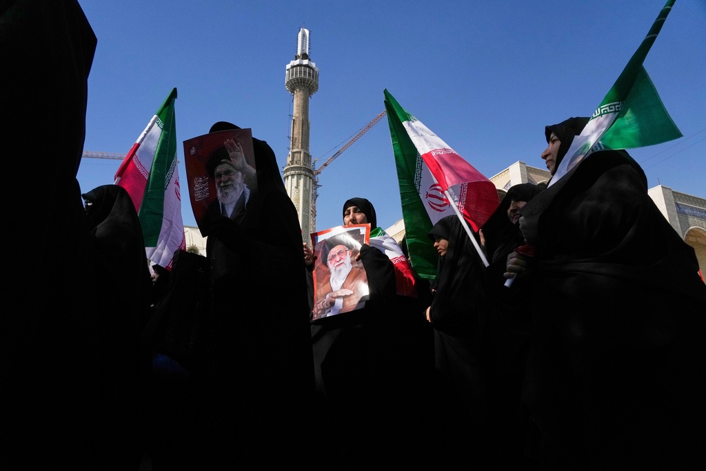 Women hold Iranian flags and pictures of the late Iranian Supreme Leader Ali Khamenei as government supporters march against the ongoing U.S.-Israeli military campaign after Friday prayers at the Imam Khomeini Grand mosque in Tehran, Iran, Friday, March 6, 2026. (AP Photo/Vahid Salemi)