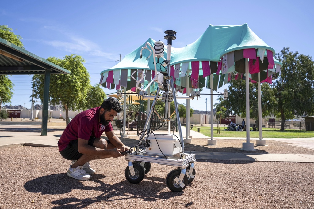 Arizona State University doctoral student Muhammad Abdullah sets up MaRTY, an instrument used to take measurements in direct sun and shade, at the Reflections on Sunnyslope shade structure, Saturday, Aug. 30, 2025, at Sunnyslope Park in Phoenix. (AP Photo/Samantha Chow)