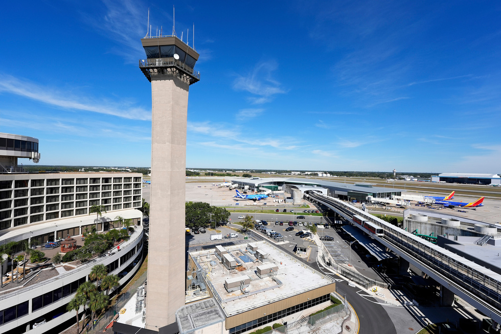 FILE - Airplanes are parked at gates near the air traffic control tower at the Tampa International Airport, Nov. 11, 2025, in Tampa, Fla. (AP Photo/Chris O'Meara, File)