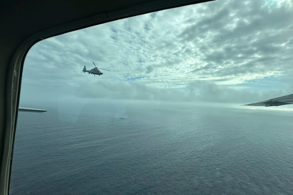FILE - A Chinese military helicopter flies close to a Philippine Bureau of Fisheries and Aquatic (BFAR) aircraft above Scarborough shoal on Feb. 18, 2025. (AP Photo/Joeal Calupitan, File)