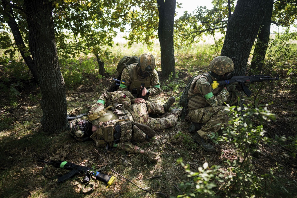 A Ukrainian National Guard serviceman of 3rd brigade «Spartan» applies a tourniquet to his comrade during a training not far from the frontline on Pokrovsk direction, Ukraine, on Friday, August 8, 2025. (AP Photo/Evgeniy Maloletka)