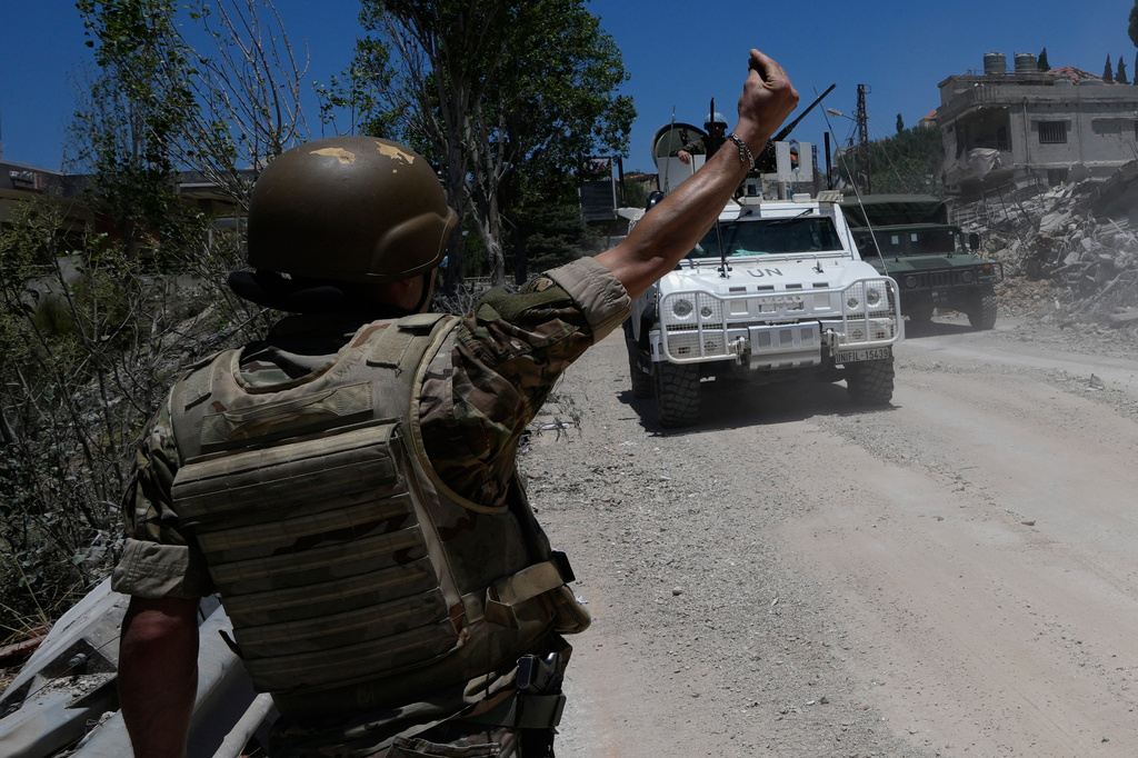 A Lebanese soldier gestures in front of a Spanish U.N peacekeeper vehicle Dibbine village, southeast Lebanon, Friday, June 5, 2026, a day after Israeli forces withdrew following clashes with Hezbollah fighters. (AP Photo/Hussein Malla)