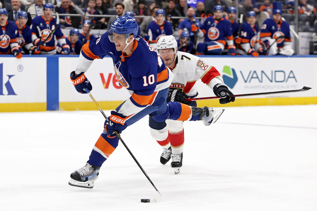 New York Islanders center Brayden Schenn (10) shoots and scores a goal in front of Florida Panthers defenseman Dmitry Kulikov in the second period of an NHL hockey game Saturday, March 28, 2026, in Elmont, N.Y. (AP Photo/Adam Hunger)