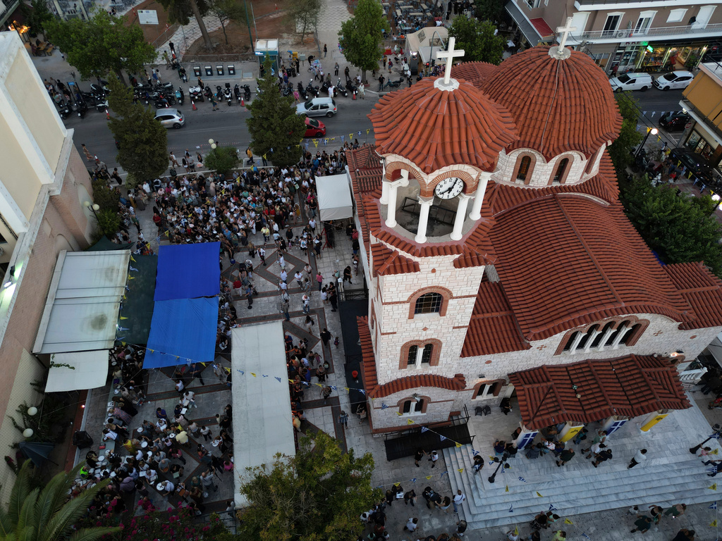 Pilgrims wait in line to have their Fanouropites, orange-flavored cakes, blessed at the Church of St. Fanourios in Athens, Wednesday, Aug. 26, 2026. (AP Photo/Thanassis Stavrakis)