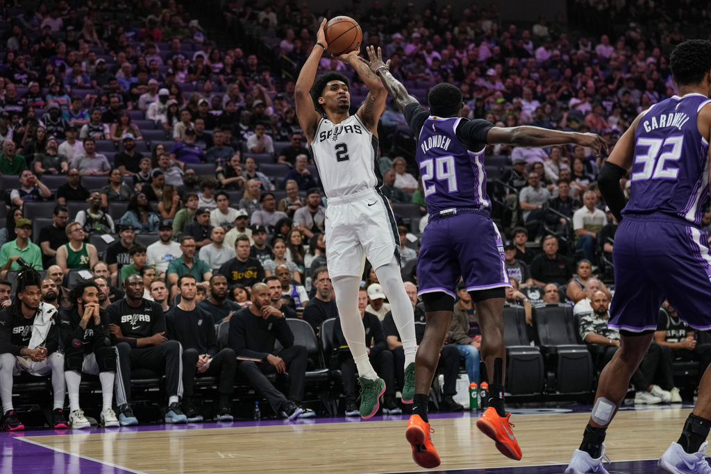 San Antonio Spurs guard Dylan Harper (2) shoots over Sacramento Kings guard Daeqwon Plowden (29) during the first half of an NBA basketball game, Tuesday, March 17, 2026, in Sacramento, Calif. (AP Photo/Justine Willard)