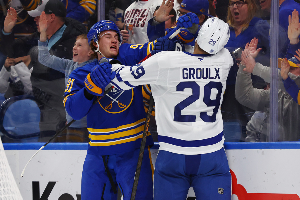 Buffalo Sabres right wing Josh Doan (91) and Toronto Maple Leafs center Bo Groulx (29) tie each other up behind the net during the first period of an NHL hockey game Saturday, March 14, 2026, in Buffalo, N.Y. (AP Photo/Jeffrey T. Barnes)