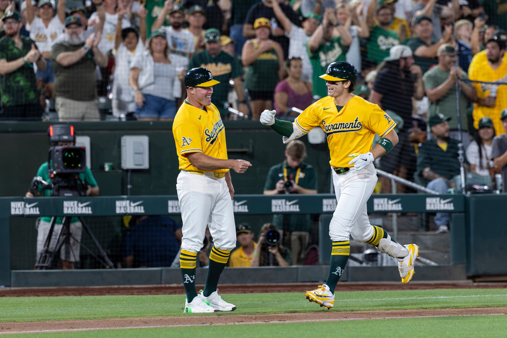 Athletics' Tyler Soderstrom, right, fist bumps third base coach Bobby Crosby after hitting a two-run home run during the sixth inning of a baseball game against the Washington Nationals, Saturday, July 18, 2026, in West Sacramento, Calif. (AP Photo/Sara Nevis)