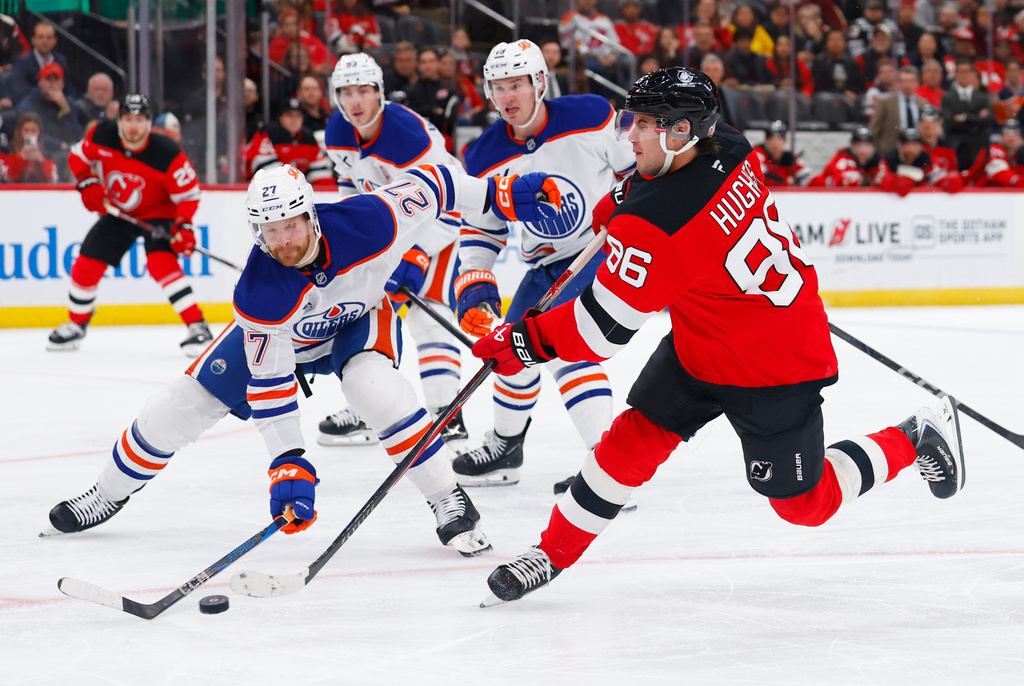 CORRECTS YEAR TO 2025, NOT 2024 - New Jersey Devils center Jack Hughes (86) scores a goal against Edmonton Oilers defenseman Brett Kulak (27) during the second period of an NHL hockey game, Saturday, Oct. 18, 2025, in Newark, N.J. (AP Photo/Noah K. Murray)