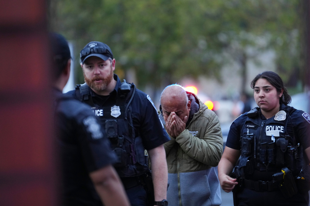 An unidentified man is led into the scene by police after they responded to a shooting at Seattle Center during the Bite of Seattle food festival Sunday, July 26, 2026, in Seattle, Wash. (AP Photo/Lindsey Wasson)