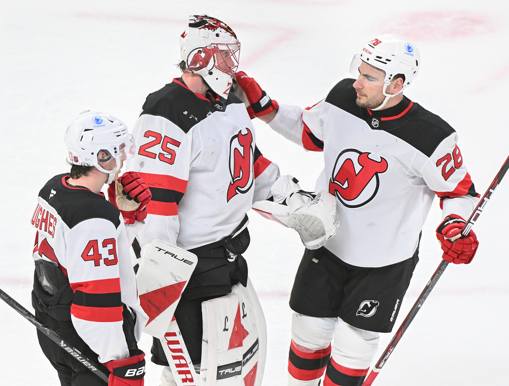 New Jersey Devils goaltender Jacob Markstrom (25), Timo Meier (28) and Luke Hughes (43) celebrate their win over the Montreal Canadiens in an NHL hockey game in Montreal, Sunday, April 5, 2026. (Graham Hughes/The Canadian Press via AP)