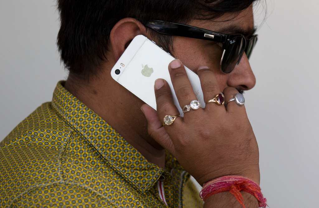 FILE - A man talks on his iPhone in New Delhi, India, Wednesday, May 18, 2016. (AP Photo/Tsering Topgyal, File)