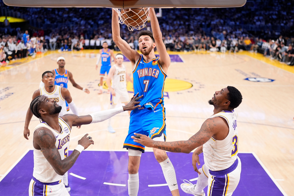 Oklahoma City Thunder center Chet Holmgren, center, dunks as Los Angeles Lakers center Deandre Ayton, left, and guard Marcus Smart defend during the first half of Game 3 in a second-round NBA basketball playoffs series Saturday, May 9, 2026, in Los Angeles. (AP Photo/Mark J. Terrill)