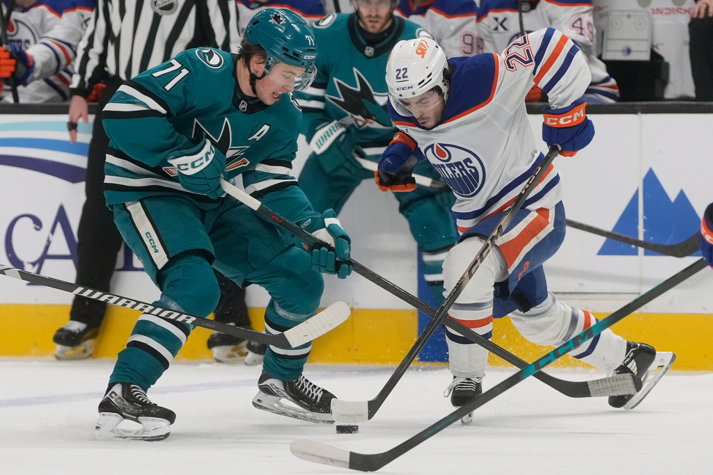 Edmonton Oilers center Matt Savoie (22) skates toward with the puck against San Jose Sharks center Macklin Celebrini (71) during the first period of an NHL hockey game in San Jose, Calif., Saturday, Feb. 28, 2026. (AP Photo/Jeff Chiu)