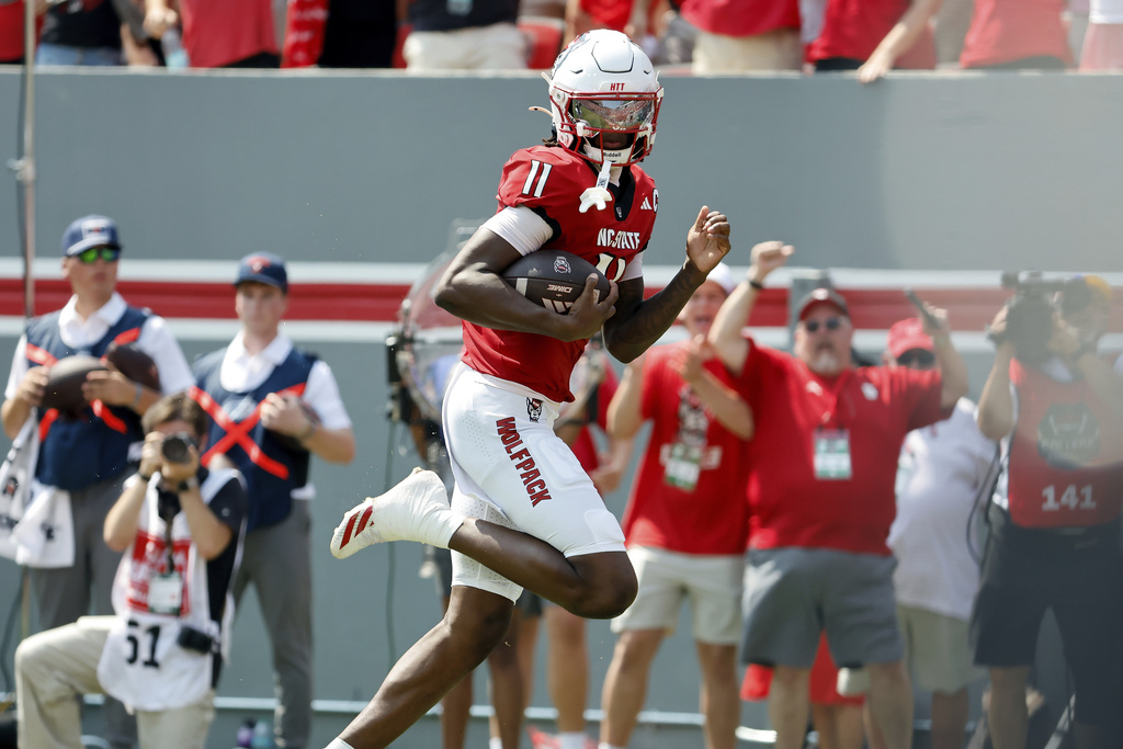 North Carolina State's CJ Bailey (11) scores a touchdown against Virginia during the second half of an NCAA college football game in Raleigh, N.C., Saturday, Sept. 6, 2025. (AP Photo/Karl DeBlaker)