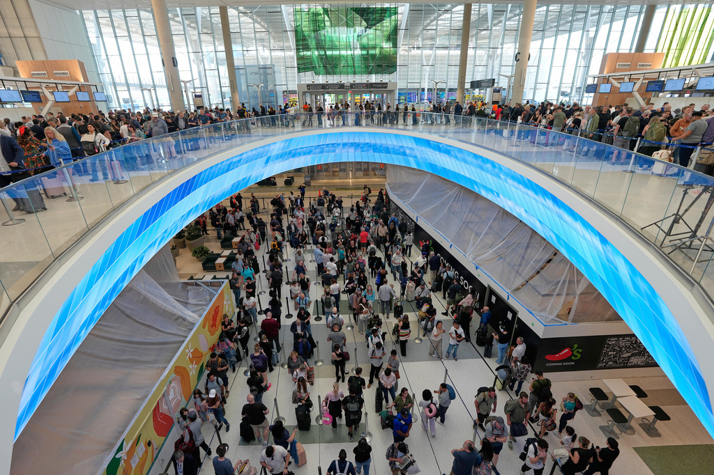 Travelers wait in long security checkpoint lines at George Bush Intercontinental Airport Friday, March 27, 2026, in Houston. (AP Photo/David J. Phillip)