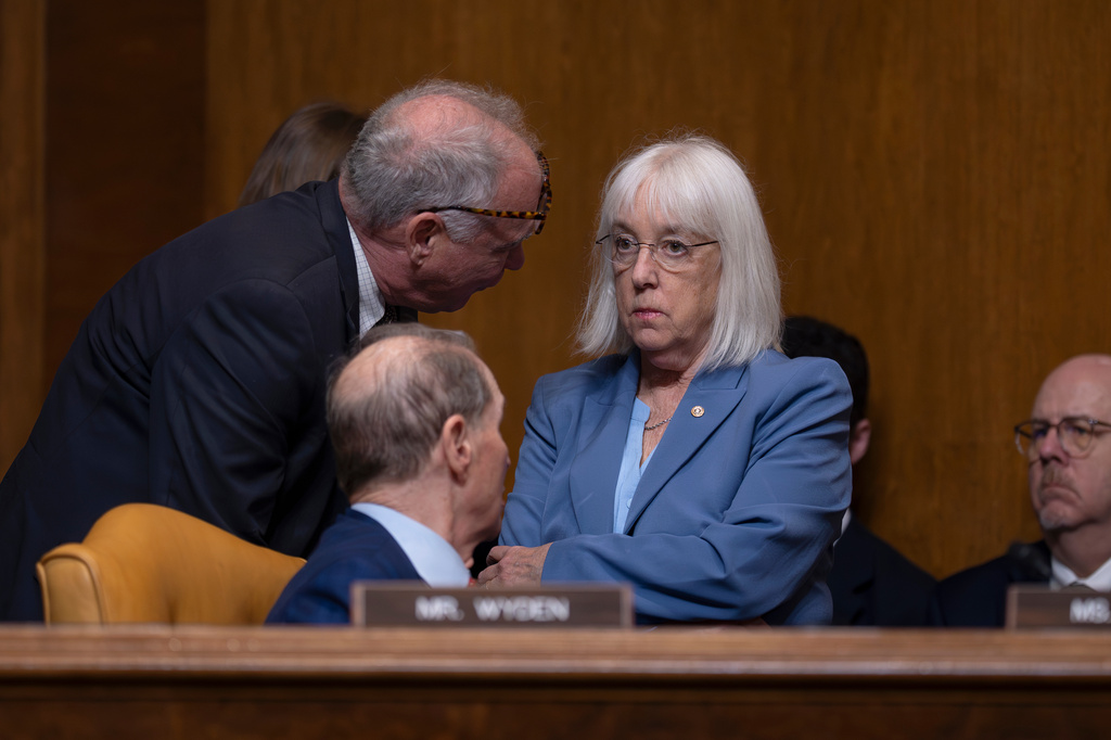 Senate Budget Committee Democrats, Sen. Tim Kaine, D-Va., left, Sen. Patty Murray, D-Wash., and Sen. Ron Wyden, D-Ore., seated, confer as Office of Management and Budget Director Russell Vought tells the panel that it'll take a massive upfront investment to ramp up U.S. weapons production and build more ships, planes and drones, at the Capitol in Washington, Thursday, April 16, 2026. (AP Photo/J. Scott Applewhite)