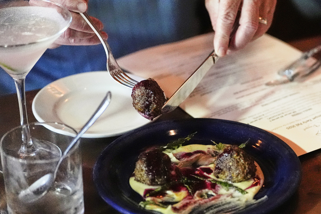 Lebanese lamb meatball, which includeds locally foraged ingredients, is selected by a patron during dinner service at the Black Trumpet restaurant, Tuesday, Sept. 16, 2025, in Portsmouth, N.H. (AP Photo/Charles Krupa)