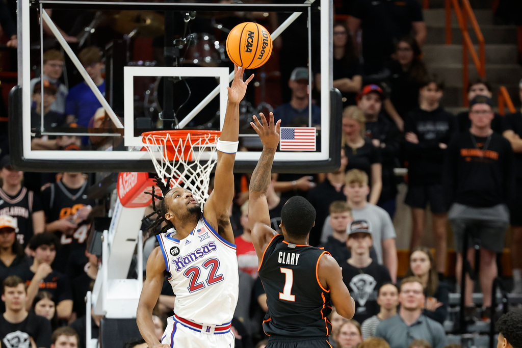 Kansas guard Darryn Peterson (22) blocks a shot by Oklahoma State guard Kanye Clary (1) during the first half of an NCAA college basketball game Wednesday, Feb. 18, 2026, in Stillwater, Okla. (AP Photo/Alonzo Adams)