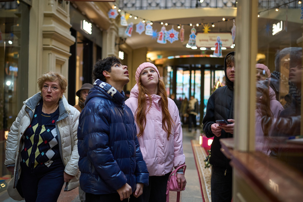 A young couple look at a boutique inside the GUM department store, decorated for Christmas and the New Year festivities in Moscow, Russia, Thursday, Nov. 20, 2025. (AP Photo/Alexander Zemlianichenko)