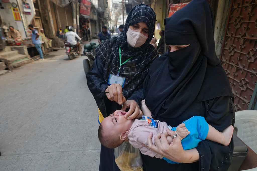 A health worker administers a polio vaccine to a child in Lahore, in Lahore, Pakistan, Monday, April 13, 2026. (AP Photo/K.M. Chaudary)