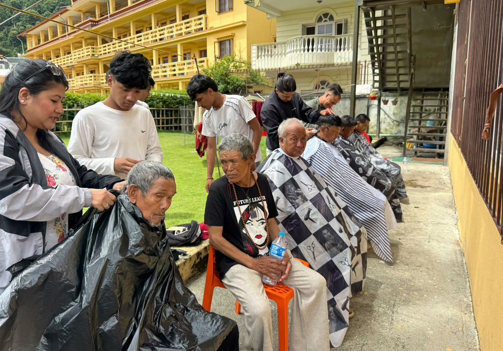 Survivors have their hair cut at a monastery where people are taking refuge in Kathmandu, Nepal, Monday, Aug. 31, 2026. (AP Photo/Niranjan Shrestha)