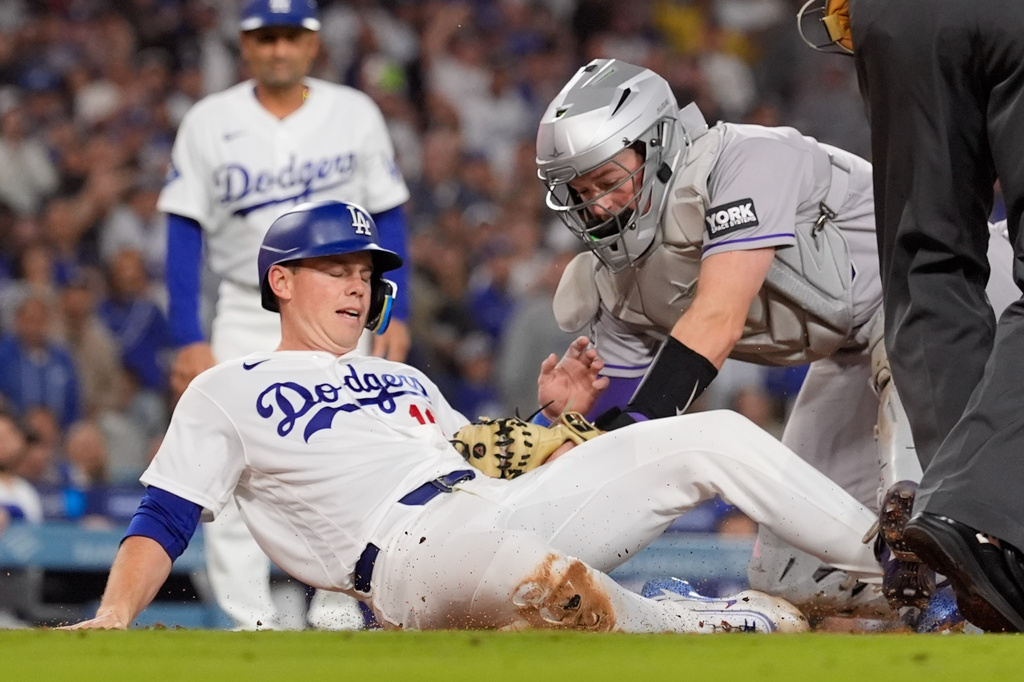 Los Angeles Dodgers' Will Smith, left, is tagged out by Colorado Rockies catcher Hunter Goodman as he tries to score on a single by Alex Call during the fourth inning of a baseball game Wednesday, May 27, 2026, in Los Angeles. (AP Photo/Mark J. Terrill)