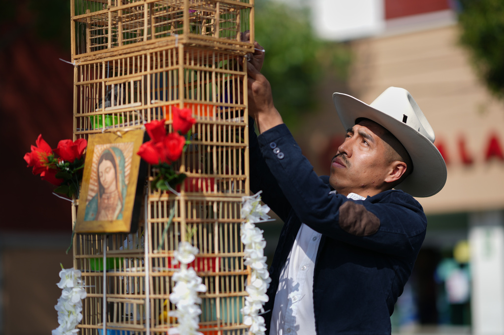 A vendor prepares a cage containing his birds before an annual pilgrimage of bird vendors to the Basilica of Guadalupe in Mexico City, Sunday, March 29, 2026. (AP Photo/Eduardo Verdugo)