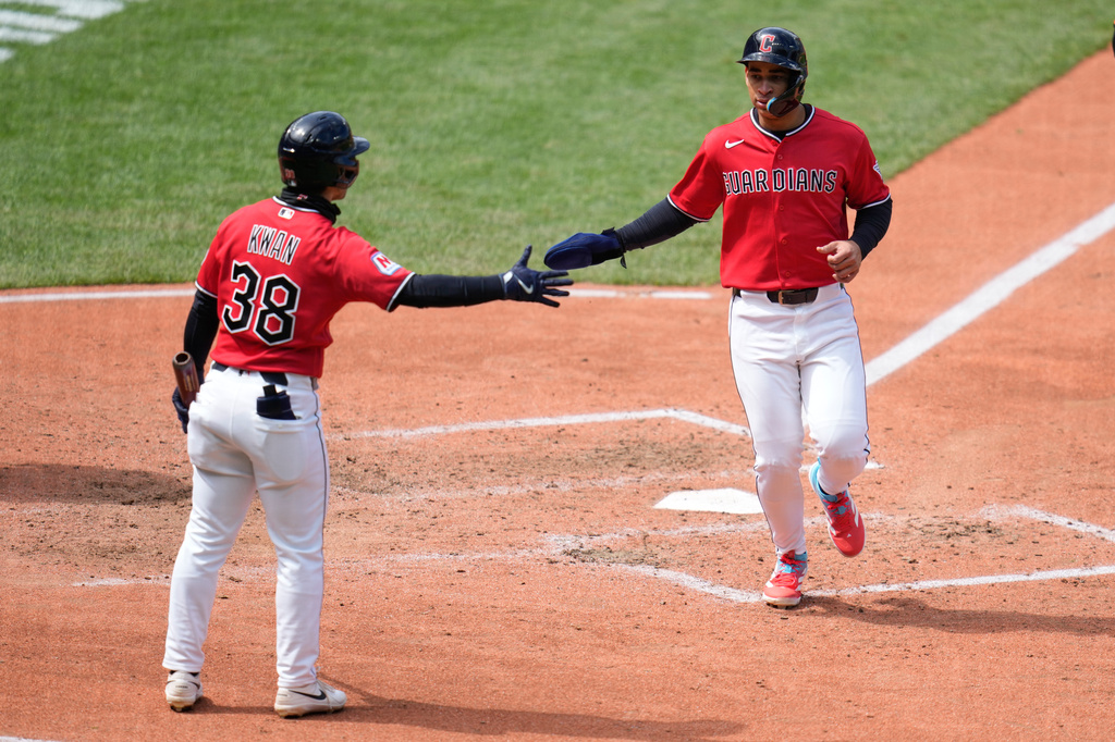 Cleveland Guardians' Juan Brito, right, is congratulated by Steven Kwan (38) as he scores in the fourth inning of a baseball game against the Baltimore Orioles in Cleveland, Sunday, April 19, 2026. (AP Photo/Sue Ogrocki)