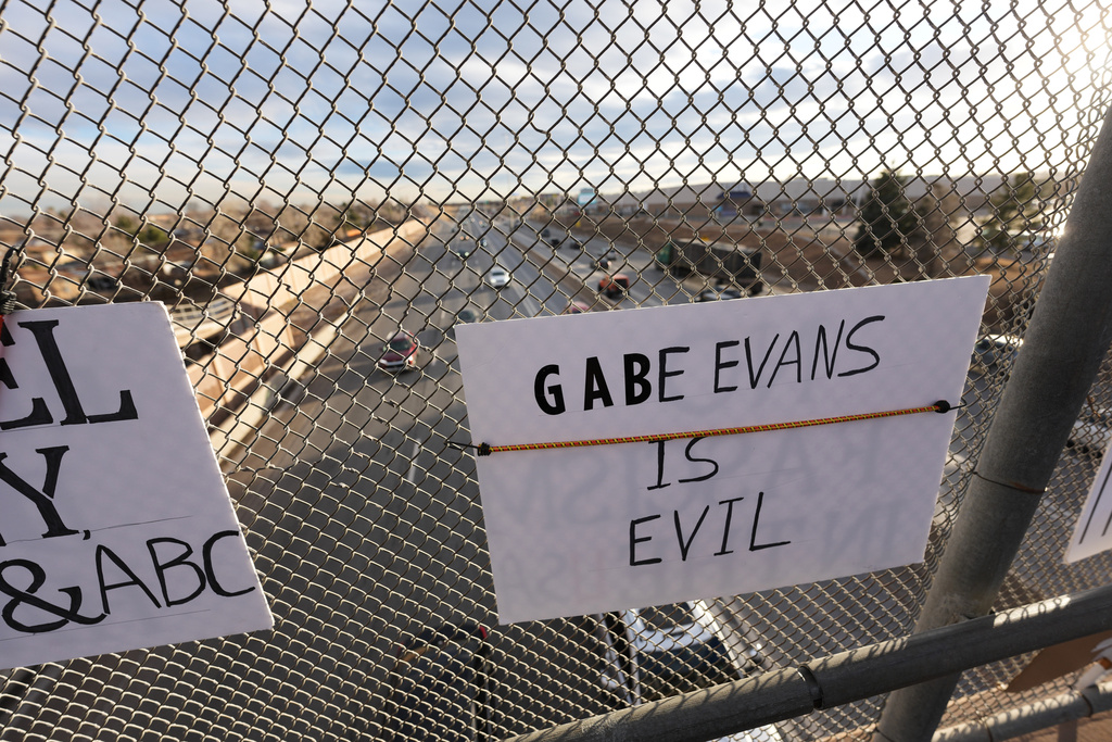 A sign against Rep. Gabe Evans, R-Colo, hangs from a fence Jan. 28, 2026, from an overpass along Interstate 25 in Northglenn, Colo. (AP Photo/David Zalubowski)