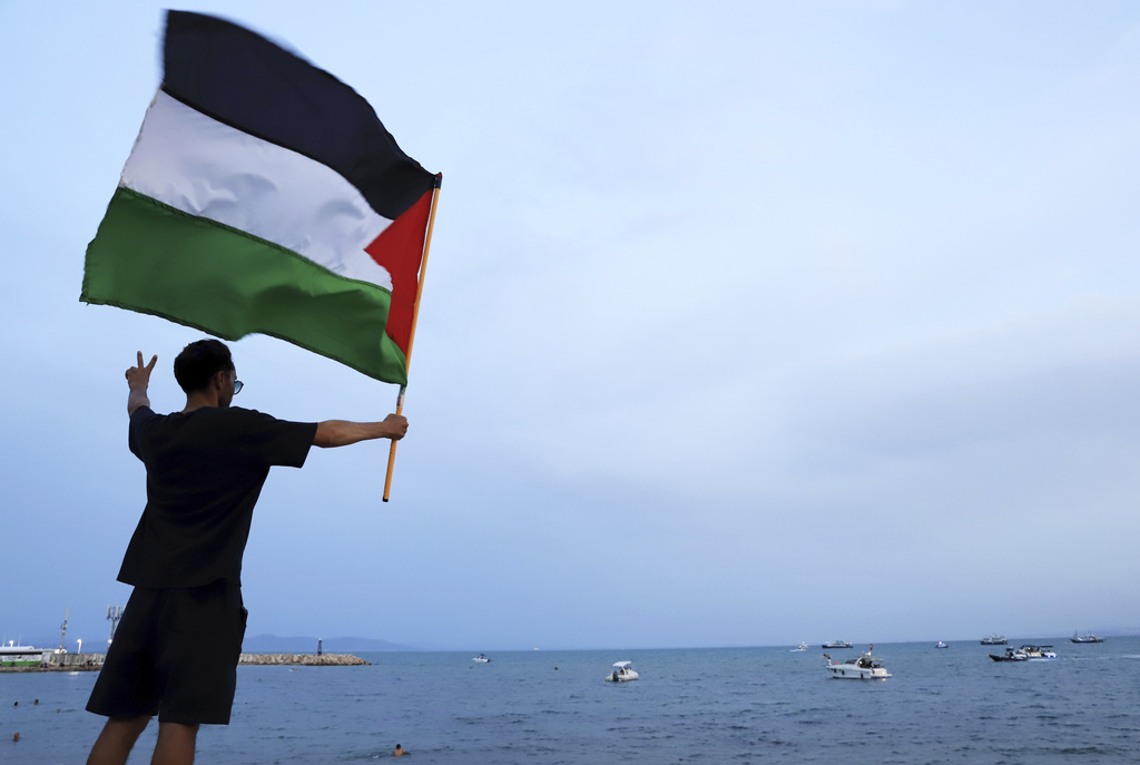 A protester waves a Palestinian flag in support of the the Global Sumud Flotilla as it arrives at the port of Sidi Bou Saïd, in Tunis, Tunisia, Sunday, Sept. 7, 2025. (AP Photo/Anis Mili)