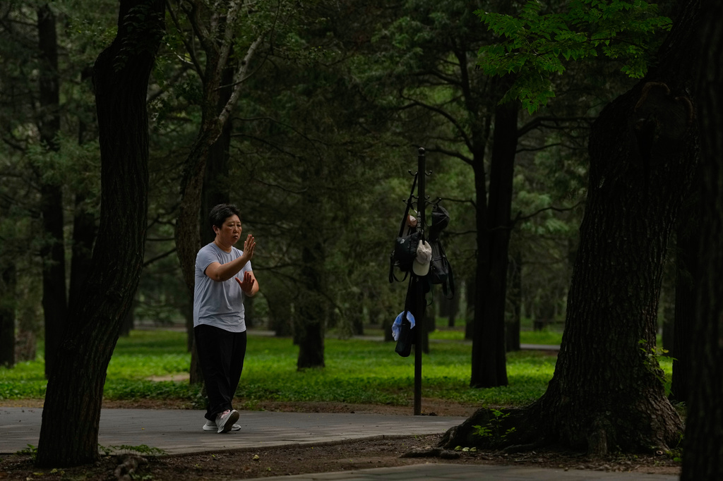 A woman practices Tai Chi at a park near the Temple of Heaven in Beijing, Thursday July 9, 2026. (AP Photo/Andy Wong)