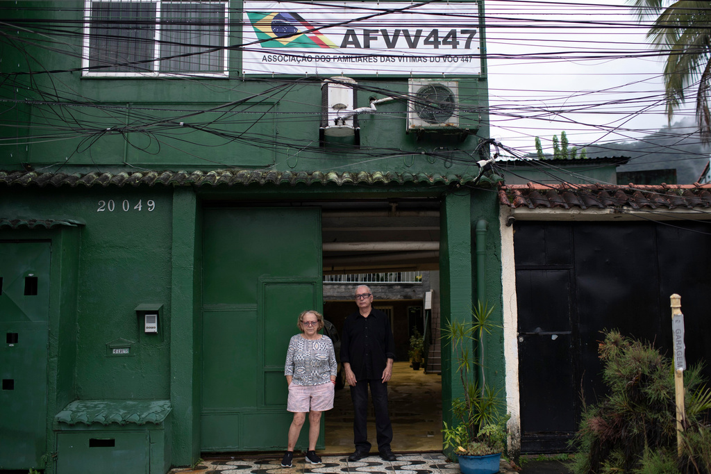 Nelson Faria Marinho and Maria Eva Marinho, who lost their son Nelson Marinho in the Air France flight 447 plane crash near the coast of Brazil on June 1, 2009, pose for a photo outside their home, where a sign with the flight number hangs in Rio de Janeiro, Thursday, May 21, 2026. (AP Photo/Bruna Prado)