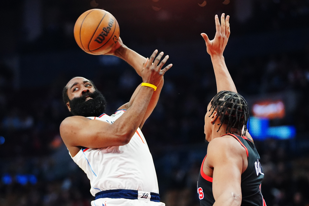 Los Angeles Clippers' James Harden, left, looks to pass the ball over Toronto Raptors' Scottie Barnes, right, during first-half NBA basketball game action in Toronto, Friday, Jan. 16, 2026. (Frank Gunn/The Canadian Press via AP)