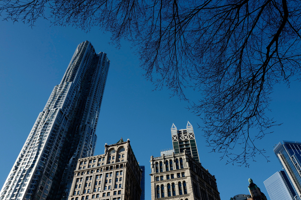 CORRECTS TO BEEKMAN - FILE - The Beekman Tower, left, designed by architect Frank Gehry towers over older architecture, in New York, March 5, 2018. (AP Photo/Mark Lennihan, File)