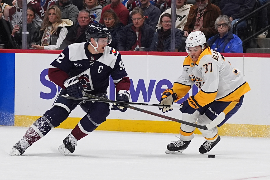 Colorado Avalanche left wing Gabriel Landeskog, left, loses control of the puck as Nashville Predators defenseman Nick Blankenburg covers in the first period of an NHL hockey game, Saturday, Dec. 13, 2025, in Denver. (AP Photo/David Zalubowski)