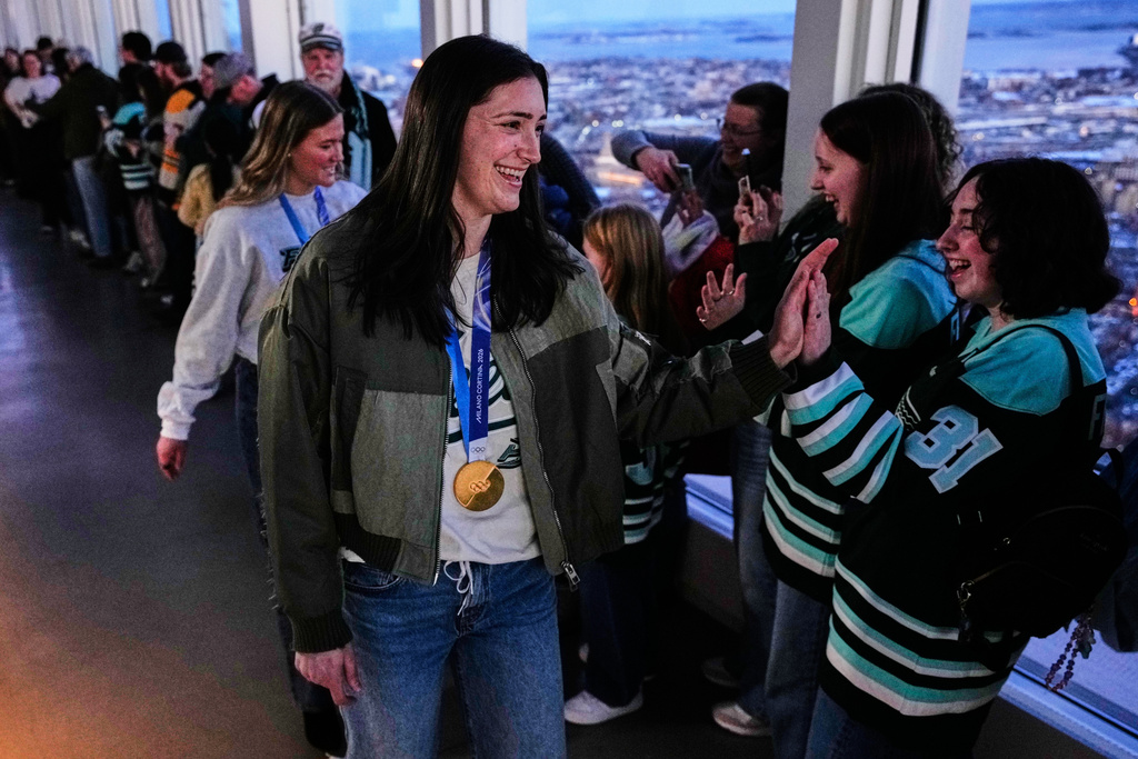 United States women's gold medal hockey players Megan Keller, center, and Haley Winn, rear left, are greeted during a gathering with fans, Monday, March 2, 2026, in Boston. (AP Photo/Charles Krupa)