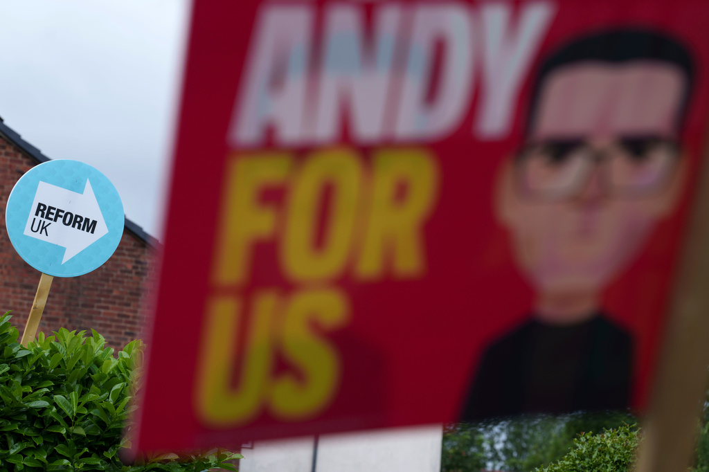 Campaign posters for Andy Burnham and for the Reform UK party are displayed in the town of Ashton-in-Makerfield before the forthcoming Makerfield by-election, in Greater Manchester, England, Tuesday, June 9, 2026. (AP Photo/Jon Super)