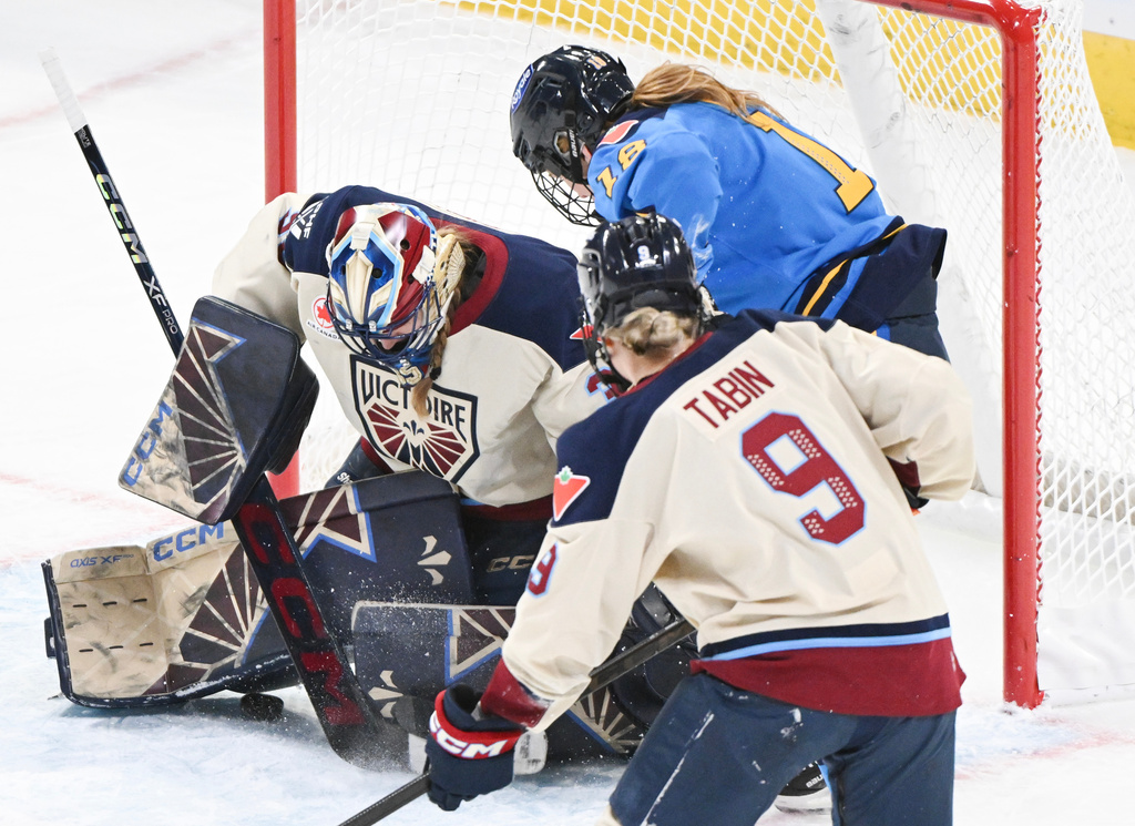 Toronto Sceptres' Jesse Compher, back, scores against Montreal Victoire goaltender Ann-Renee Desbiens as Victoire's Kati Tabin (9) defends during the first period of a PWHL hockey game in Montreal, Saturday, Dec. 27, 2025. (Graham Hughes/The Canadian Press via AP)