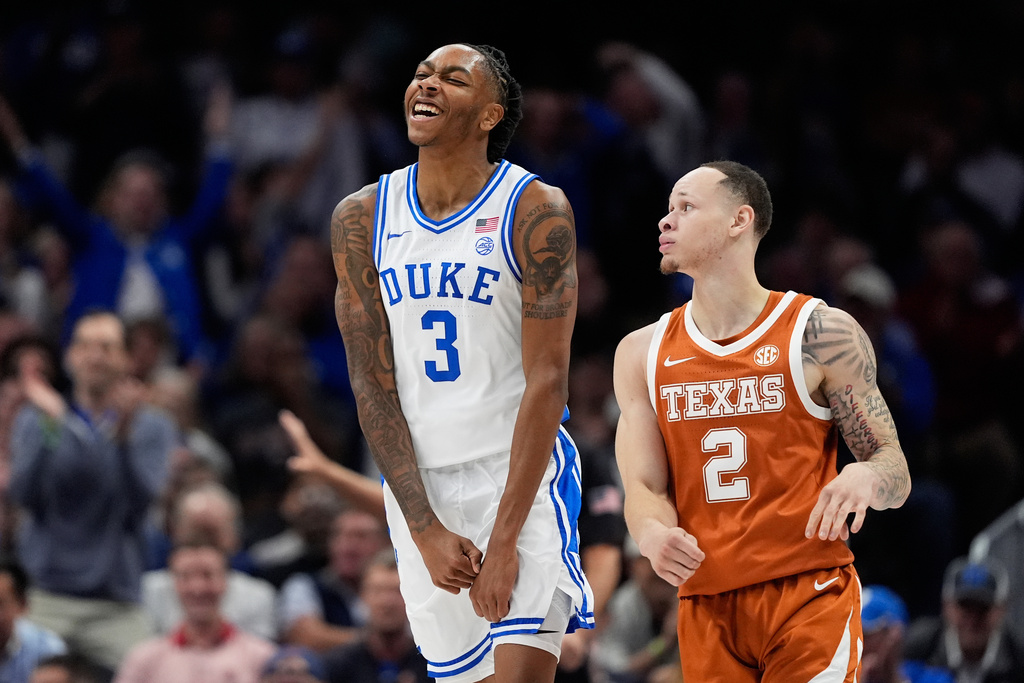 Duke guard Isaiah Evans celebrates after scoring as Texas guard Chendall Weaver looks on during the first half of an NCAA college basketball game, Tuesday, Nov. 4, 2025, in Charlotte, N.C. (AP Photo/Chris Carlson)