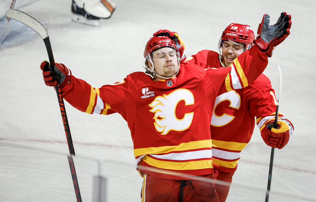Calgary Flames' Connor Zary, left, celebrates his goal with teammate John Beecher during third period NHL hockey action in Calgary on Wednesday, Dec. 31, 2025. (Jeff McIntosh/The Canadian Press via AP)