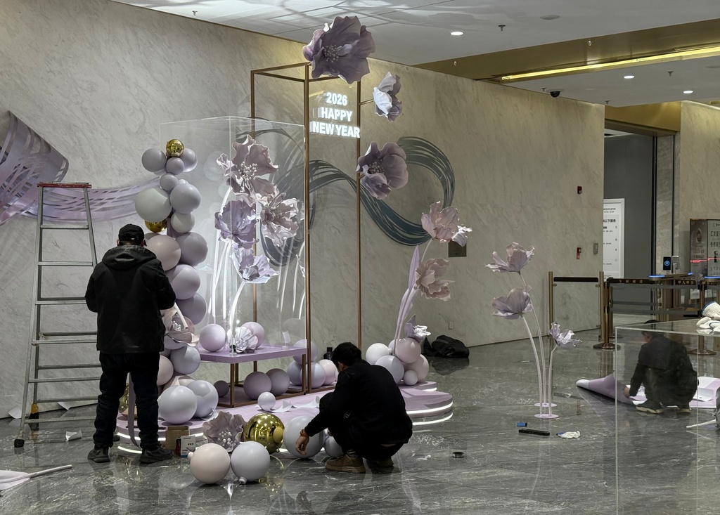 Workers prepare a display welcoming 2026 in the lobby of the LG Towers in Beijing, Saturday, Dec. 27, 2025. (AP Photo/Ted Anthony)