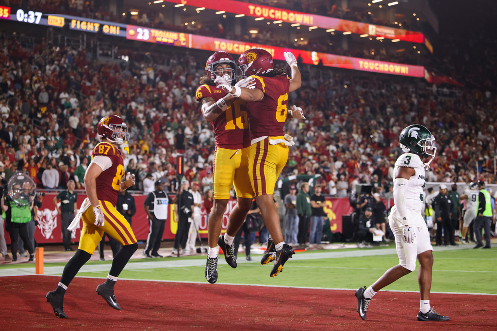 Southern California wide receiver Tanook Hines (16) and wide receiver Makai Lemon (6) celebrate after a touchdown by Hines as tight end Lake McRee, left, runs and Michigan State defensive back Jeremiah Hughes, right, looks on during the first half of NCAA college football game, Saturday, Sept. 20, 2025, Los Angeles. (AP Photo/Jessie Alcheh)