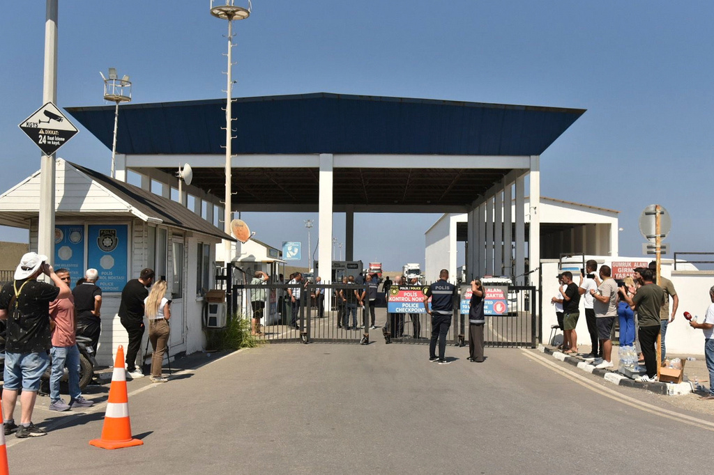 People gather outside the port of Kyrenia in the Turkish-occupied northern part of Cyprus, Sunday, Aug. 30, 2026, after a catamaran-style ferry overturned off the island's northern coast. (AP Photo)