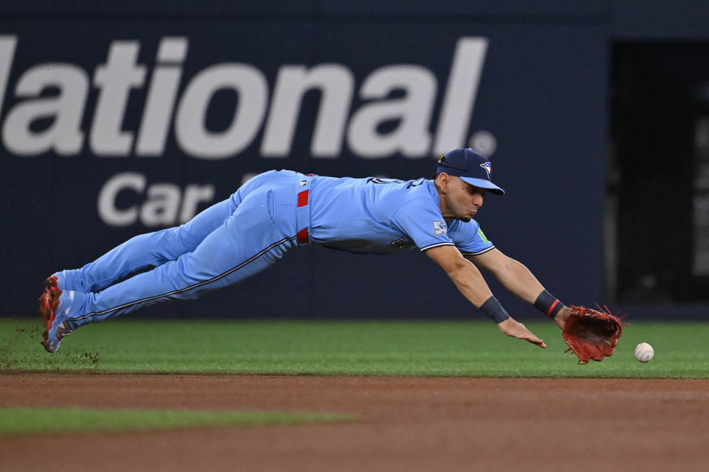 Toronto Blue Jays infielder Andres Gimenez (0) misses a ground ball off the bat of Pittsburgh Pirates' Bryan Reynolds during the first inning of a baseball game in Toronto, Saturday, May 23, 2026. (Jon Blacker/The Canadian Press via AP)