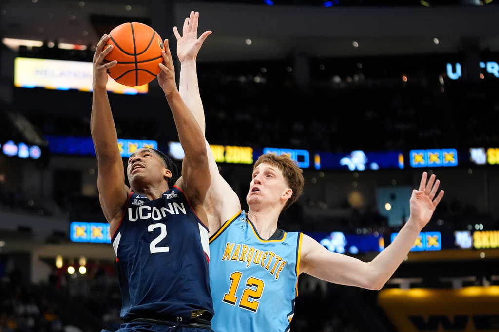 UConn's Silas Demary Jr. (2) shoots past Marquette's Ben Gold during the second half of an NCAA college basketball game Saturday, March 7, 2026, in Milwaukee. (AP Photo/Aaron Gash)