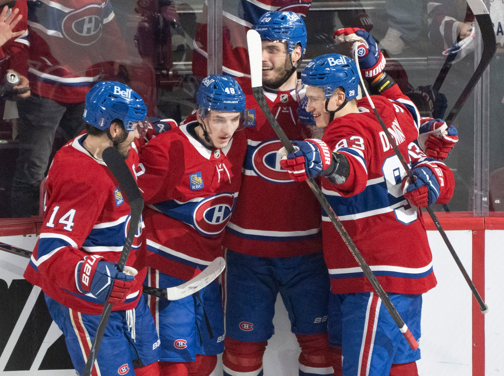 Montreal Canadiens' Lane Hutson (48) celebrates after his goal with teammates Nick Suzuki (14), Juraj Slafkovsky (20) and Ivan Demidov (93) during the second period of Game 3 of the Eastern Conference finals NHL hockey Stanley Cup playoff series against the Carolina Hurricanes in Montreal, Monday, May 25, 2026. (Christinne Muschi/The Canadian Press via AP)